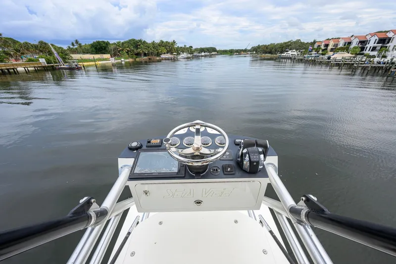 Slide: The Image of 2016 SeaVee 390Z boat helm with waterway view and residential backdrop. - 57