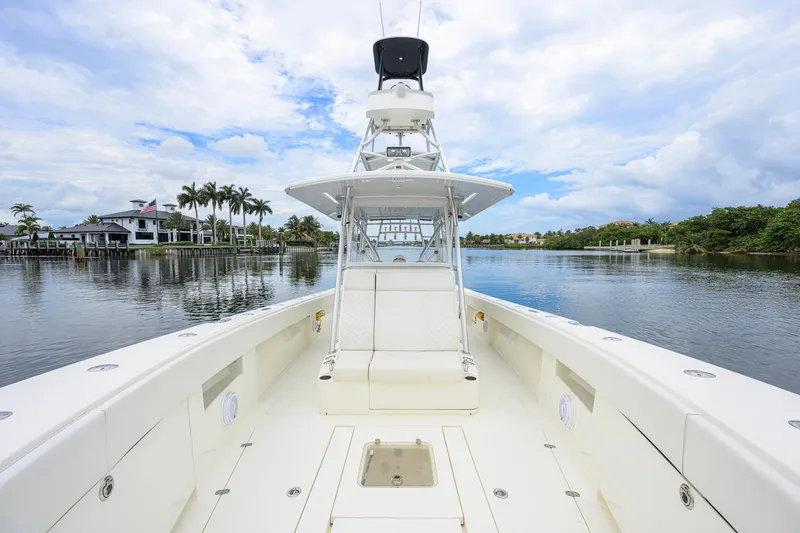 Slide: The Image of 2016 SeaVee 390Z boat on calm water with scenic waterfront view. - 5