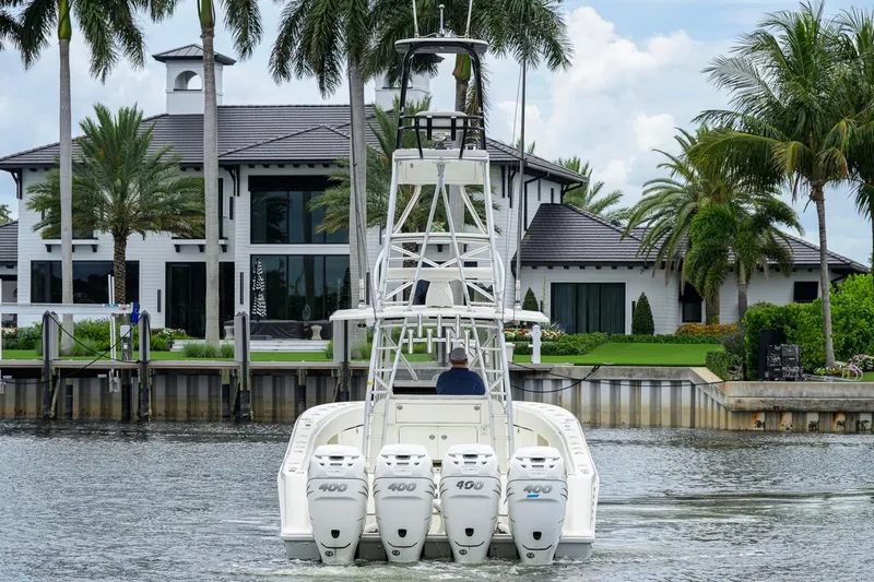 Slide: The Image of 2016 SeaVee 390Z boat cruising near a luxurious waterfront home with palm trees. - 67