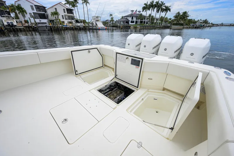 Slide: The Image of 2016 SeaVee 390Z boat with open storage compartments and multiple outboard engines, docked by waterfront homes. - 26