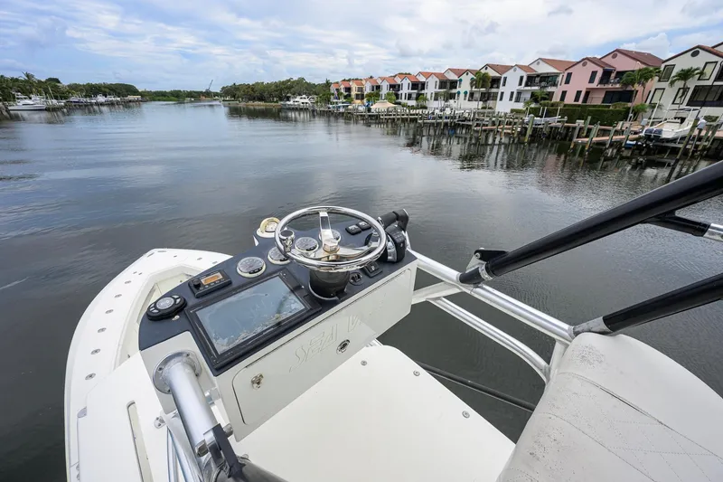 Slide: The Image of Helm of 2016 SeaVee 390Z boat overlooking waterfront homes and docks. - 58