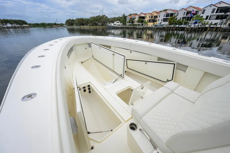 Slide: The Image of 2016 SeaVee 390Z boat interior with open storage compartments, docked by waterfront homes. - 11