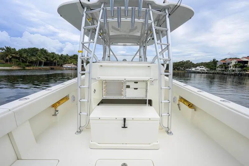 Slide: The Image of 2016 SeaVee 390Z boat interior with storage compartments and ladder, docked by a scenic waterfront. - 29