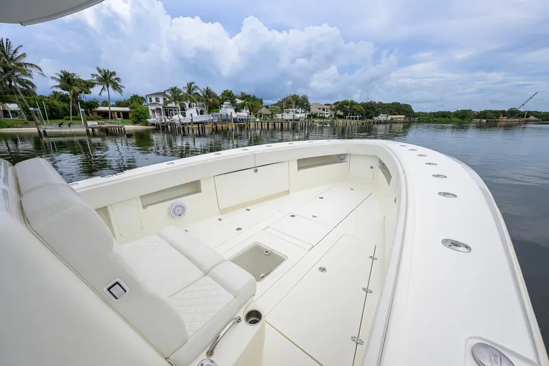 Slide: The Image of 2016 SeaVee 390Z boat with spacious deck, docked near waterfront homes under cloudy skies. - 14