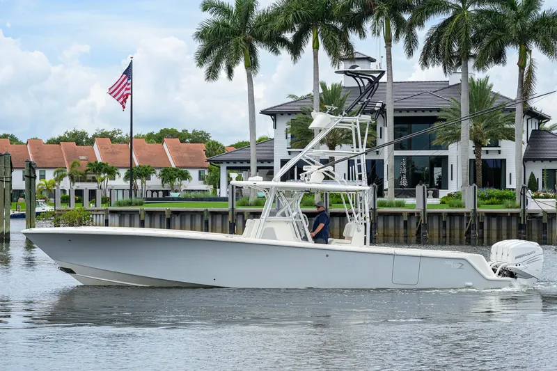 Slide: The Image of 2016 SeaVee 390Z boat cruising near waterfront homes and palm trees. - 64