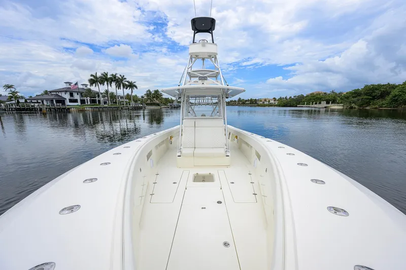Slide: The Image of 2016 SeaVee 390Z boat on calm water, surrounded by palm trees and luxury homes. - 4