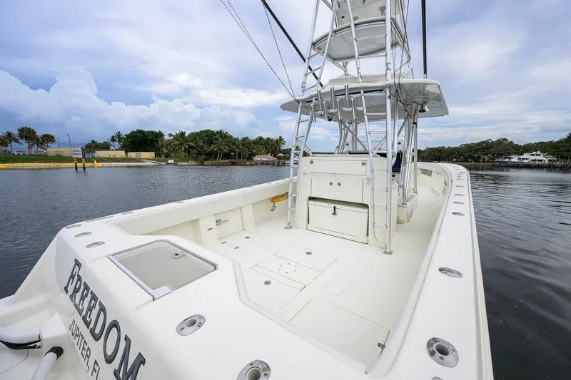 Slide: The Image of 2016 SeaVee 390Z boat with tower, docked in a serene waterfront setting. - 22