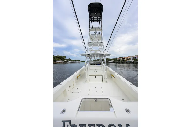 Slide: The Image of 2016 SeaVee 390Z boat with tower, docked on a calm waterway under a cloudy sky. - 20