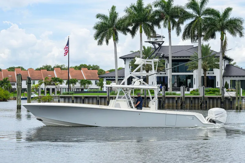 Slide: The Image of 2016 SeaVee 390Z boat cruising near waterfront homes and palm trees. - 63
