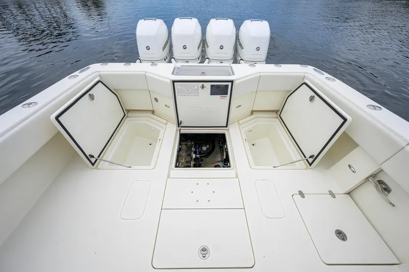 Slide: The Image of 2016 SeaVee 390Z boat deck with open storage compartments and four outboard engines. - 25