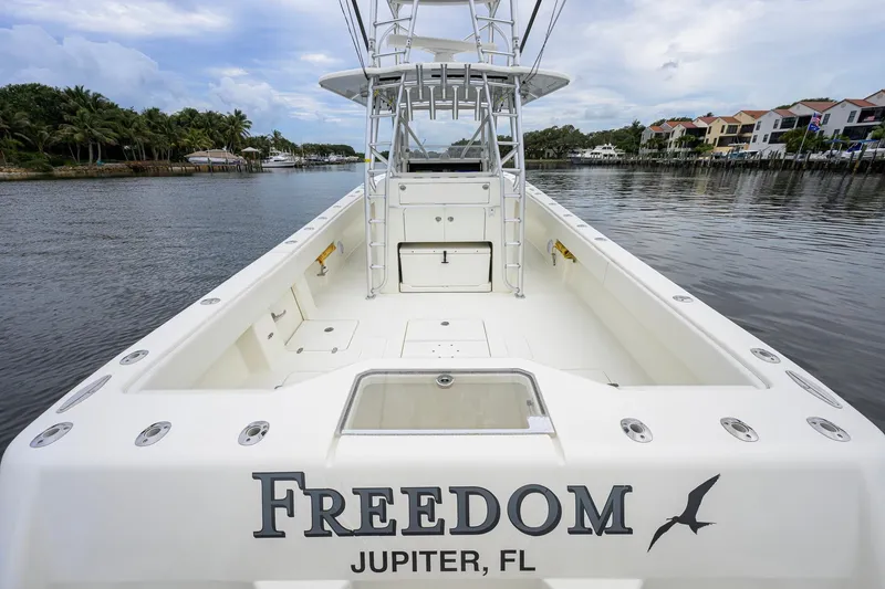 Slide: The Image of 2016 SeaVee 390Z boat named "Freedom" docked in Jupiter, FL, with spacious deck. - 19