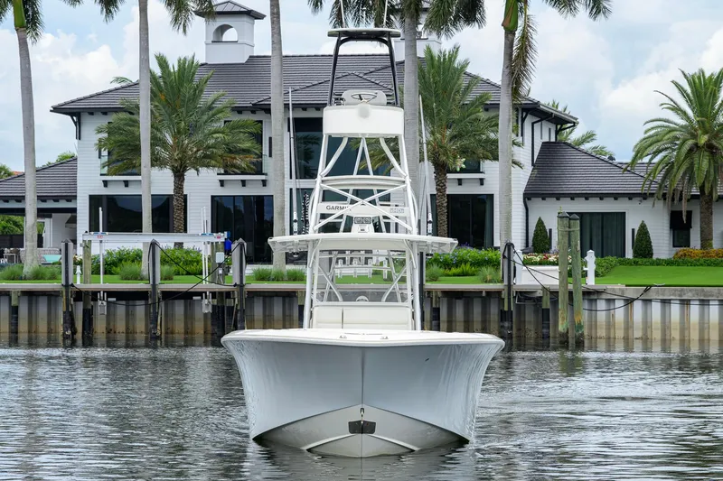 Slide: The Image of 2016 SeaVee 390Z boat docked near a luxurious waterfront home with palm trees. - 62
