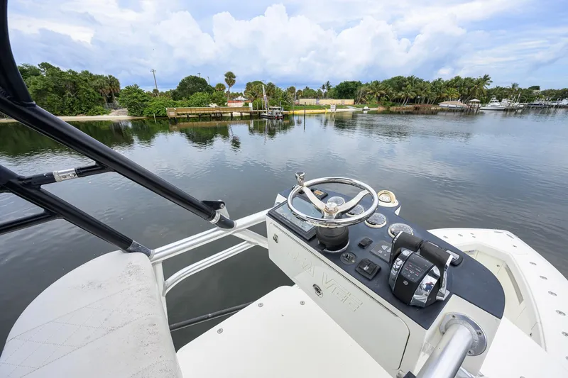 Slide: The Image of Helm of 2016 SeaVee 390Z boat overlooking serene water and lush greenery. - 56