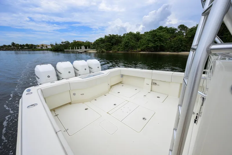 Slide: The Image of 2016 SeaVee 390Z boat with four outboard engines, cruising near lush shoreline. - 15