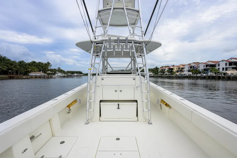 Slide: The Image of 2016 SeaVee 390Z boat with tower, docked near waterfront homes under a cloudy sky. - 21