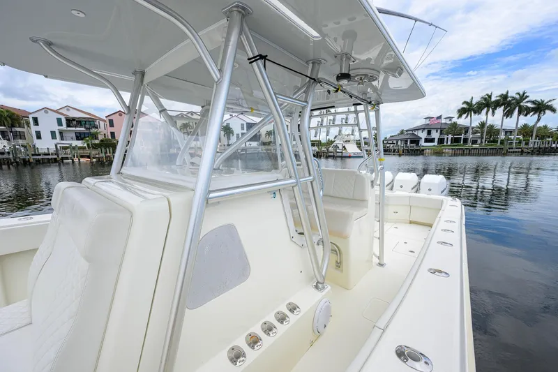 Slide: The Image of 2016 SeaVee 390Z boat with sleek design, docked near waterfront homes and palm trees. - 53