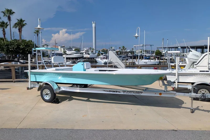The Image of 2026 Mitzi Skiffs 17 Tournament boat on trailer at marina, clear sky background. - 0