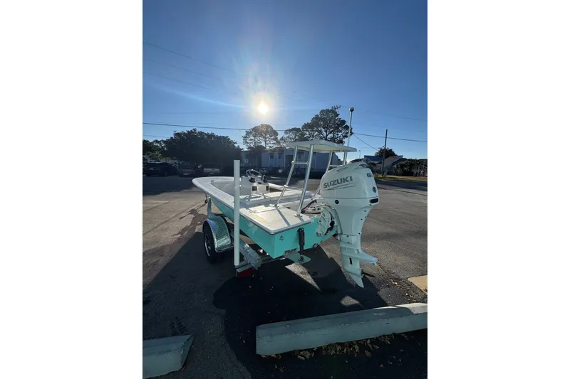 Slide: The Image of 2026 Mitzi Skiffs 17 Tournament boat with Suzuki engine in sunny parking lot. - 1