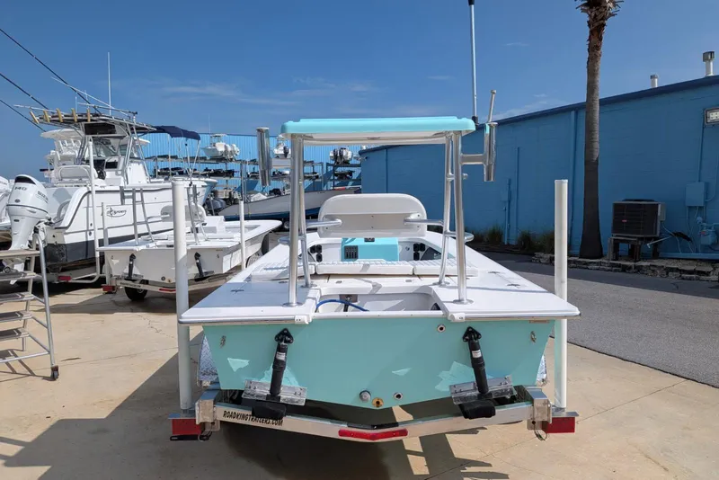 Slide: The Image of 2026 Mitzi Skiffs 17 Tournament boat in marina, light blue hull, trailer attached. - 4