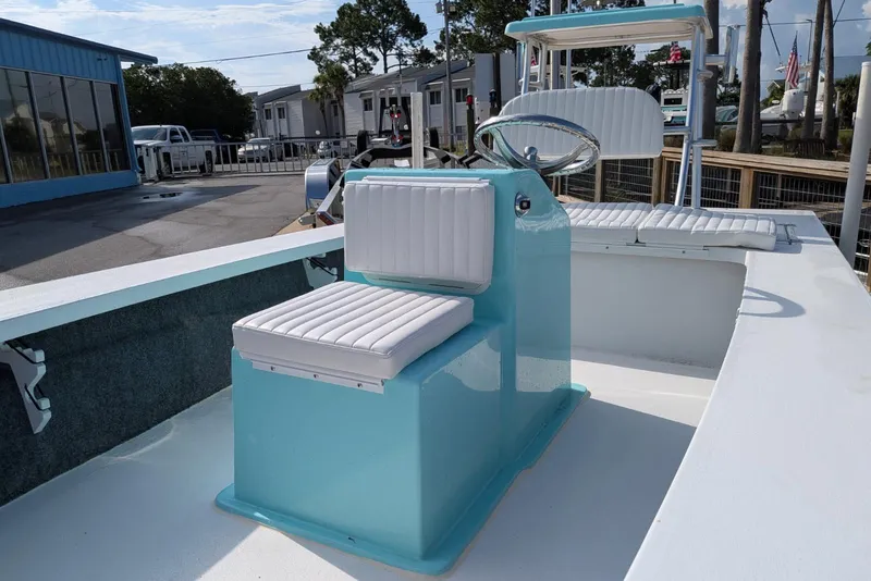 Slide: The Image of 2026 Mitzi Skiffs 17 Tournament boat with blue and white seating, docked outdoors. - 7