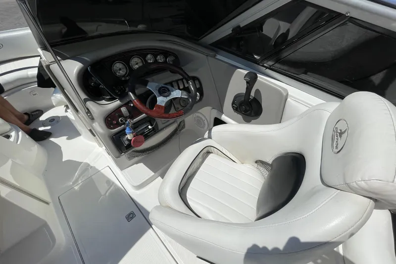 Slide: The Image of 2005 Ebbtide 2200 Bow Rider boat interior with steering wheel and white seating. - 3