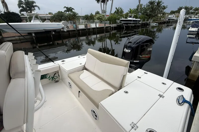 Slide: The Image of 2016 Robalo 246 Cayman boat with Yamaha 250 engine, docked in a scenic marina. - 23