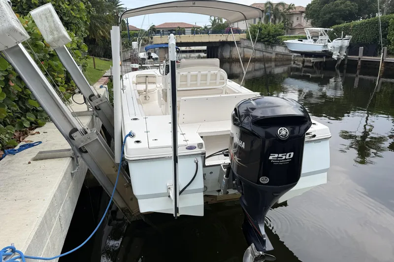 Slide: The Image of 2016 Robalo 246 Cayman boat docked with Yamaha 250 engine in a serene canal setting. - 26