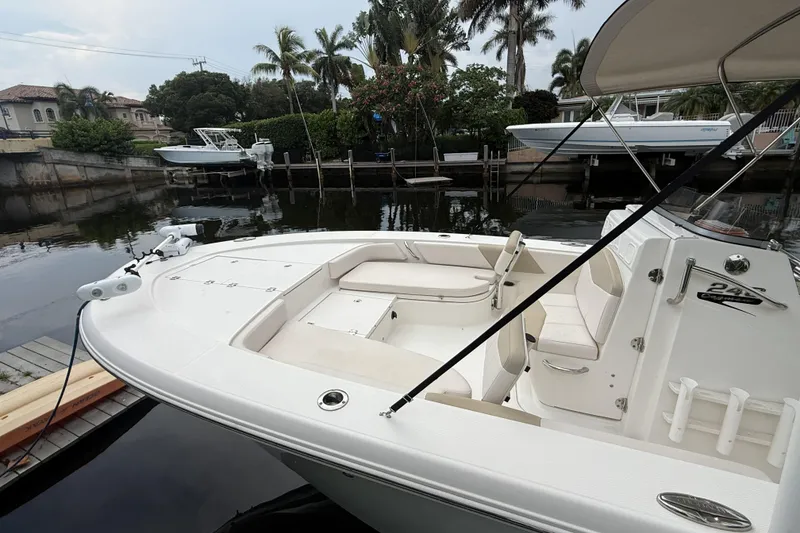 Slide: The Image of 2016 Robalo 246 Cayman boat docked by a serene waterfront with lush greenery. - 3