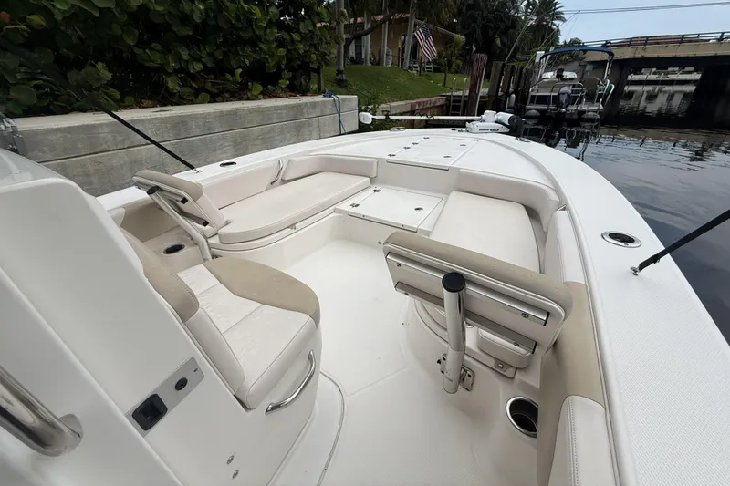Slide: The Image of 2016 Robalo 246 Cayman boat interior with seating and storage, docked by a canal. - 8