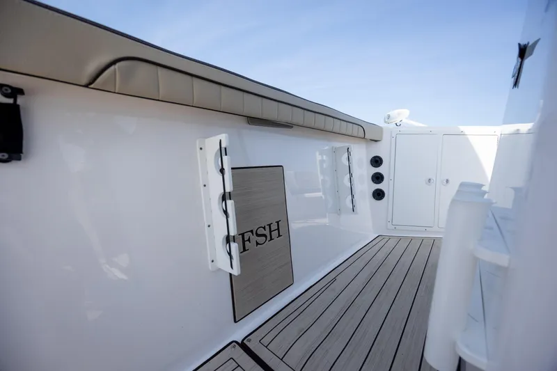 Slide: The Image of 2023 Yamaha Boats 222 FSH Sport E interior with cushioned seating and sleek design. - 14