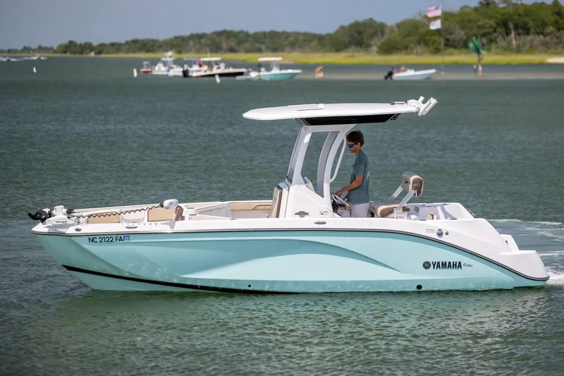 Slide: The Image of 2023 Yamaha Boats 222 FSH Sport E cruising on a serene lake. - 4
