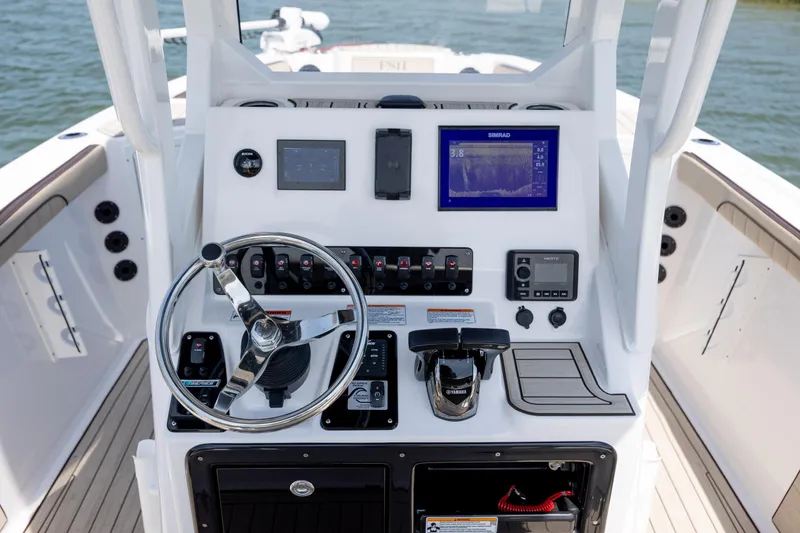 Slide: The Image of 2023 Yamaha Boats 222 FSH Sport E dashboard with steering wheel and navigation controls. - 7
