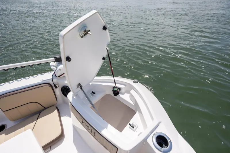Slide: The Image of 2023 Yamaha Boats 222 FSH Sport E open storage compartment on water. - 18