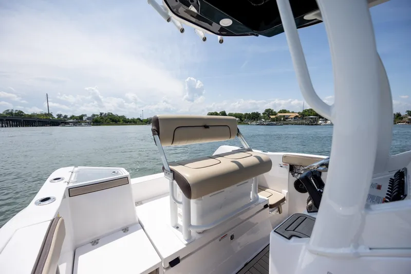 Slide: The Image of 2023 Yamaha Boats 222 FSH Sport E interior with seating, on a sunny day by the water. - 12