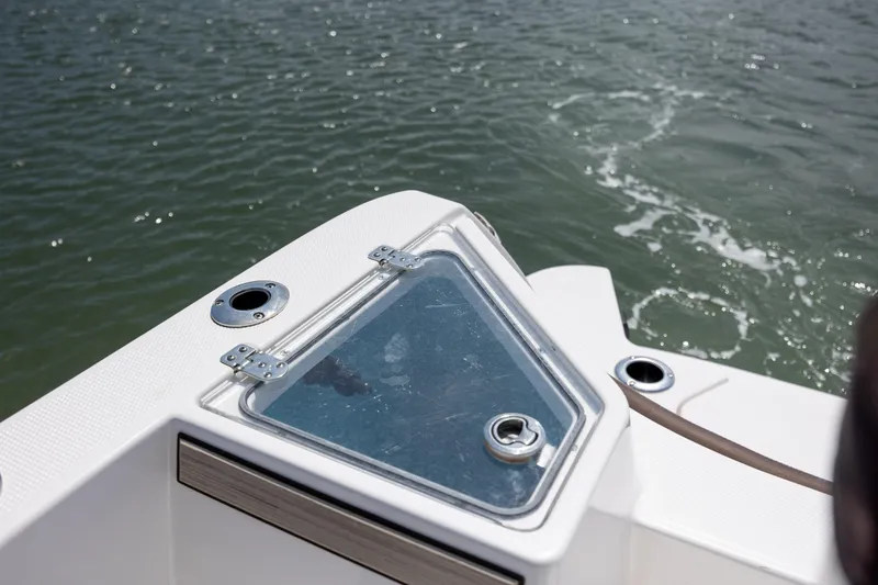 Slide: The Image of 2023 Yamaha Boats 222 FSH Sport E deck detail with water in the background. - 11