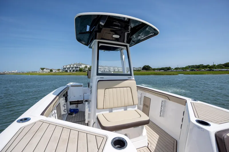 Slide: The Image of 2023 Yamaha Boats 222 FSH Sport E on water, showcasing sleek design and spacious seating. - 13