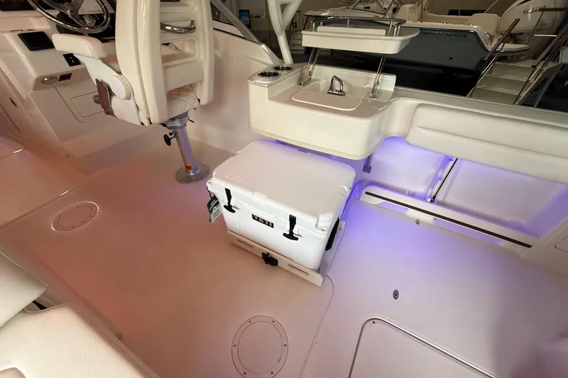 Slide: The Image of Interior of 2026 Grady-White Freedom 235 boat with seating and cooler, illuminated by soft lighting. - 20