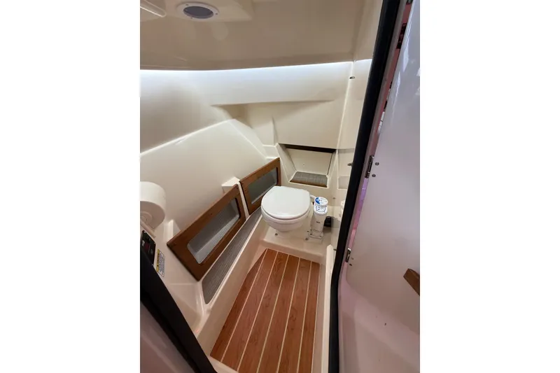 Slide: The Image of 2026 Grady-White Freedom 235 boat interior with modern marine toilet and wood flooring. - 11