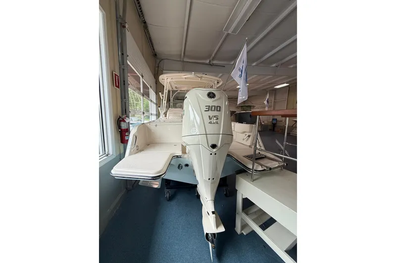 Slide: The Image of 2026 Grady-White Freedom 235 boat with 300 V6 engine displayed indoors. - 4