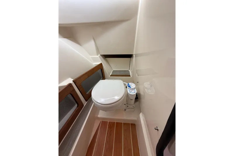 Slide: The Image of 2026 Grady-White Freedom 235 boat interior with compact marine toilet. - 29