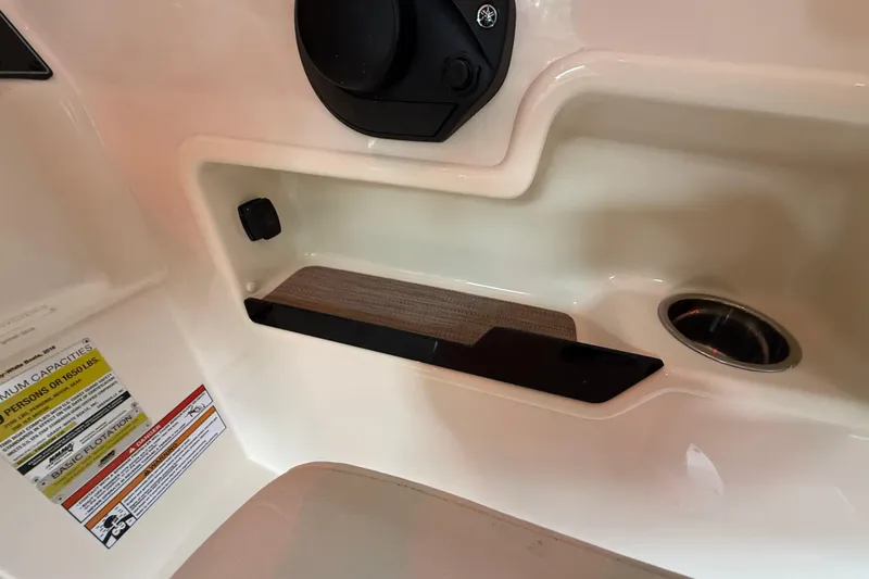 Slide: The Image of Interior detail of 2026 Grady-White Freedom 235 boat, featuring storage compartment and cup holder. - 18