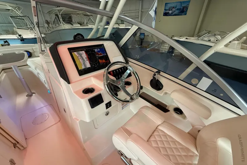 Slide: The Image of 2026 Grady-White Freedom 235 boat cockpit with modern steering and navigation display. - 16