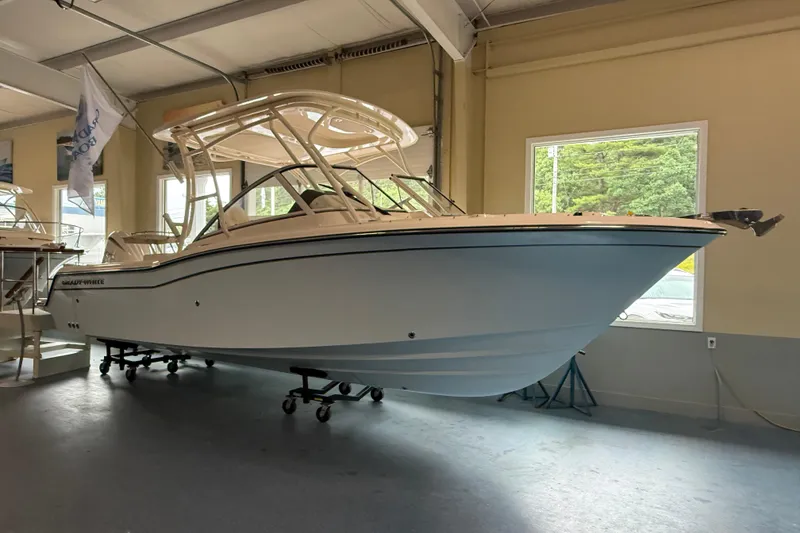 Slide: The Image of 2026 Grady-White Freedom 235 boat displayed indoors, showcasing sleek design and modern features. - 2
