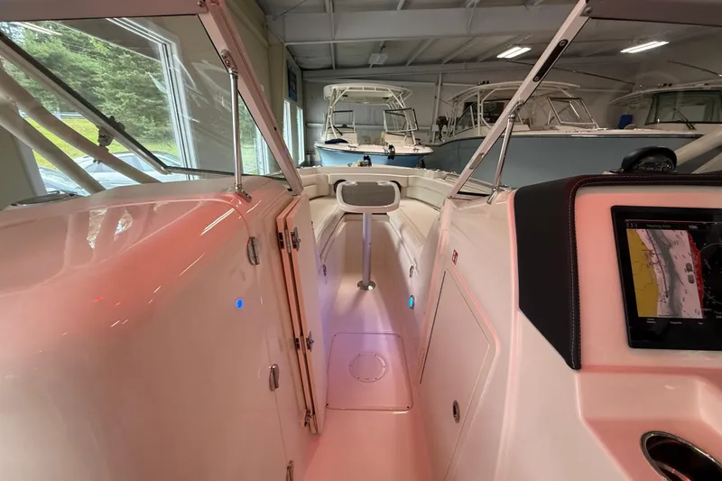 Slide: The Image of 2026 Grady-White Freedom 235 boat interior with navigation display in showroom. - 12