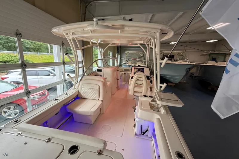 Slide: The Image of 2026 Grady-White Freedom 235 boat interior with seating and modern features in showroom. - 7