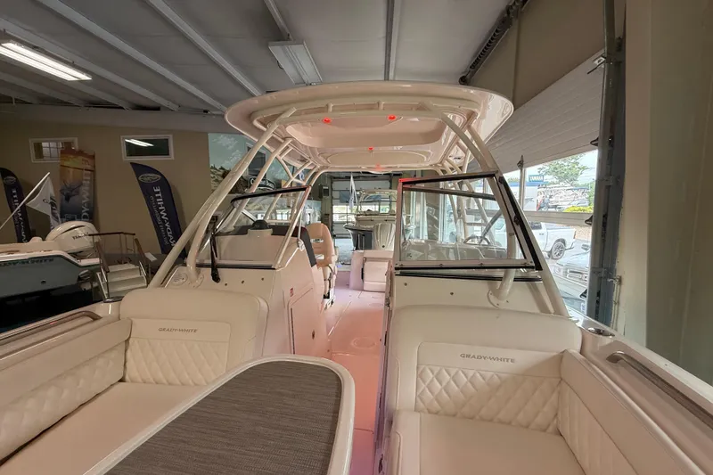 Slide: The Image of 2026 Grady-White Freedom 235 boat interior, showcasing luxurious seating and modern design in a showroom. - 14