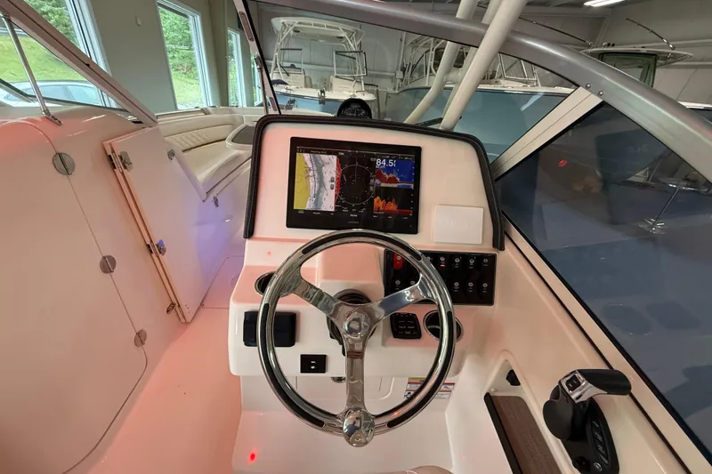 Slide: The Image of Helm of 2026 Grady-White Freedom 235 boat with modern navigation display. - 17