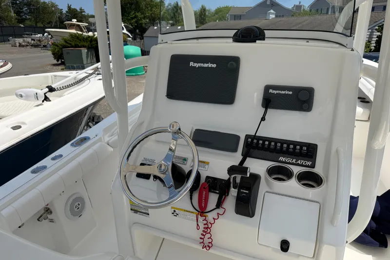 Slide: The Image of 2015 Regulator 23 Center Console boat dashboard with Raymarine electronics and steering wheel. - 15