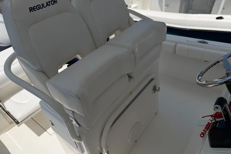 Slide: The Image of 2015 Regulator 23 Center Console boat with white seating and steering wheel. - 17