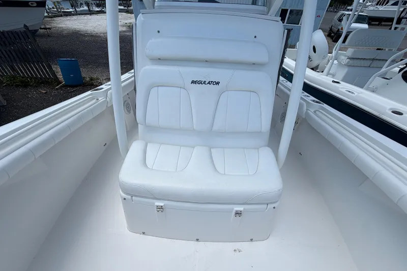 Slide: The Image of 2015 Regulator 23 Center Console boat with white seating and storage compartment. - 20